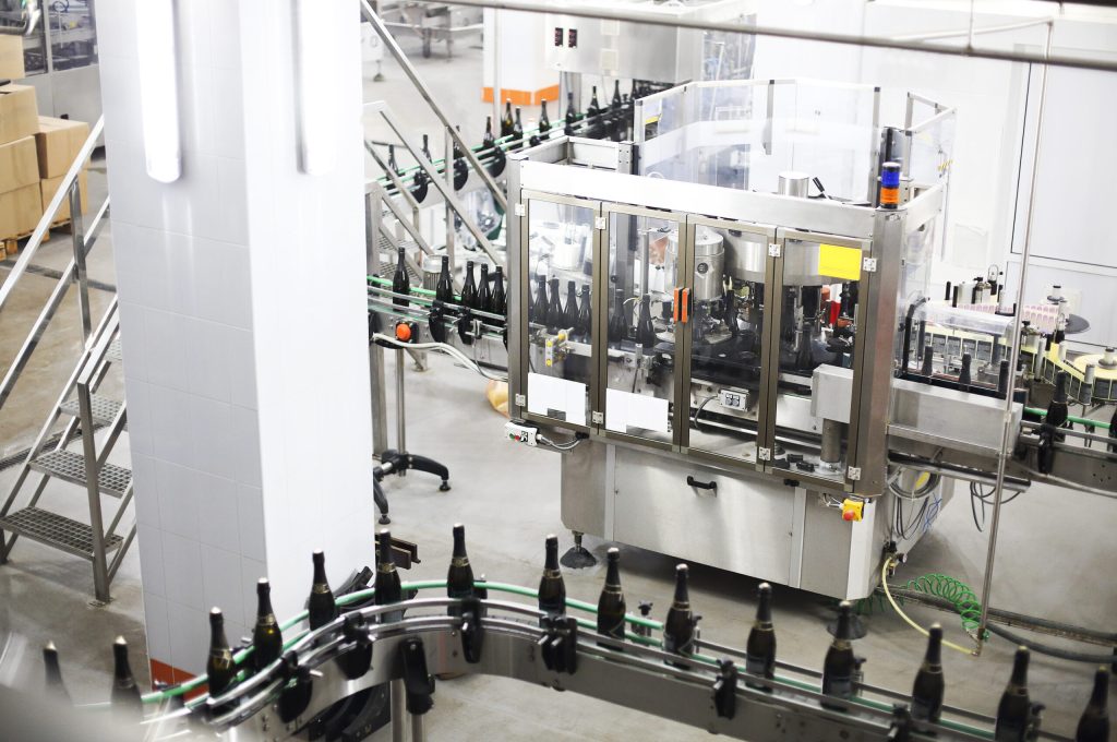 Industrial production shot with champagne bottles on the conveyor belt in a factory